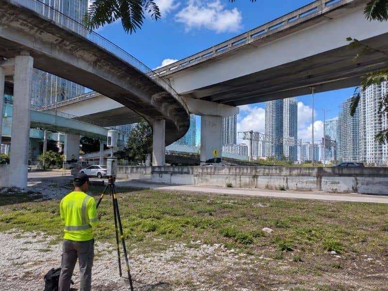 Surveyor conducts LiDAR mapping equipment used near elevated roadways and transportation infrastructure in Miami, FL