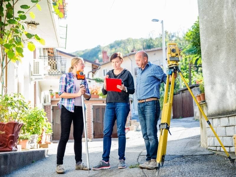Surveyor documenting gated property access, driveway entrance, and boundary conditions in Miami FL
